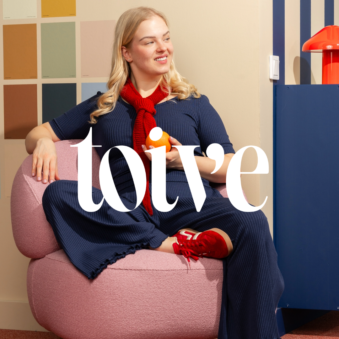 Nainen Toive-vaatebrändin sinisissä ribbivaatteissa. Kuvan päällä toiveen logo.